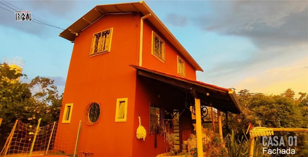 ein orangefarbenes Gebäude mit Seitenfenstern in der Unterkunft Chalé tribal Vermelho in Alto Paraíso de Goiás