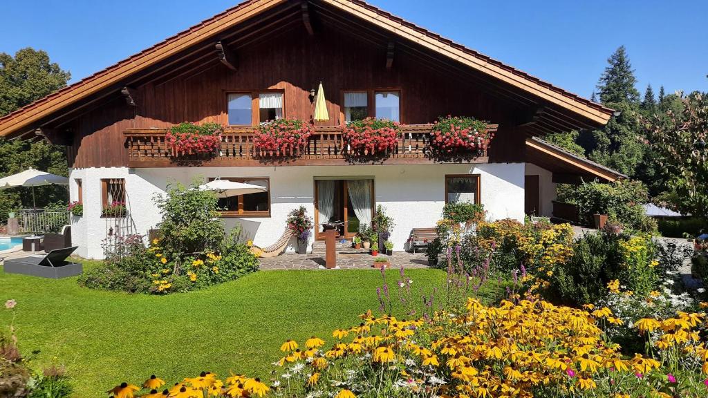 ein Haus mit einem Balkon mit Blumen im Hof in der Unterkunft Studio für 2 Personen ca 33 m in Bayerisch Eisenstein, Bayern Bayerischer Wald in Bayerisch Eisenstein