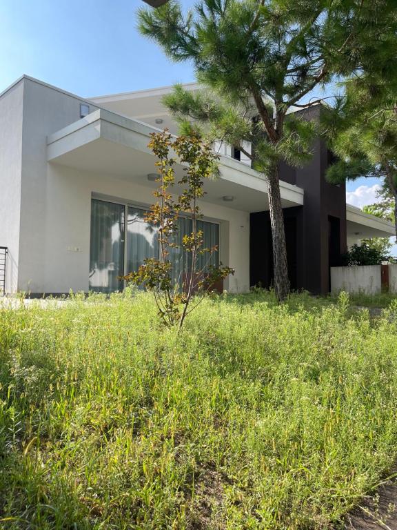 a house with a tree in the yard at Villa Malù in Lignano Sabbiadoro