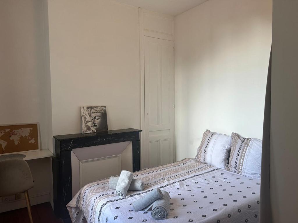 a bedroom with a bed with blue and white sheets at L'observatoire in Le Havre