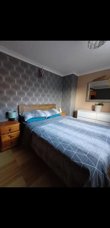 une chambre avec un grand lit avec une couverture bleue dans l'établissement Home in Thurso NC500, à Thurso