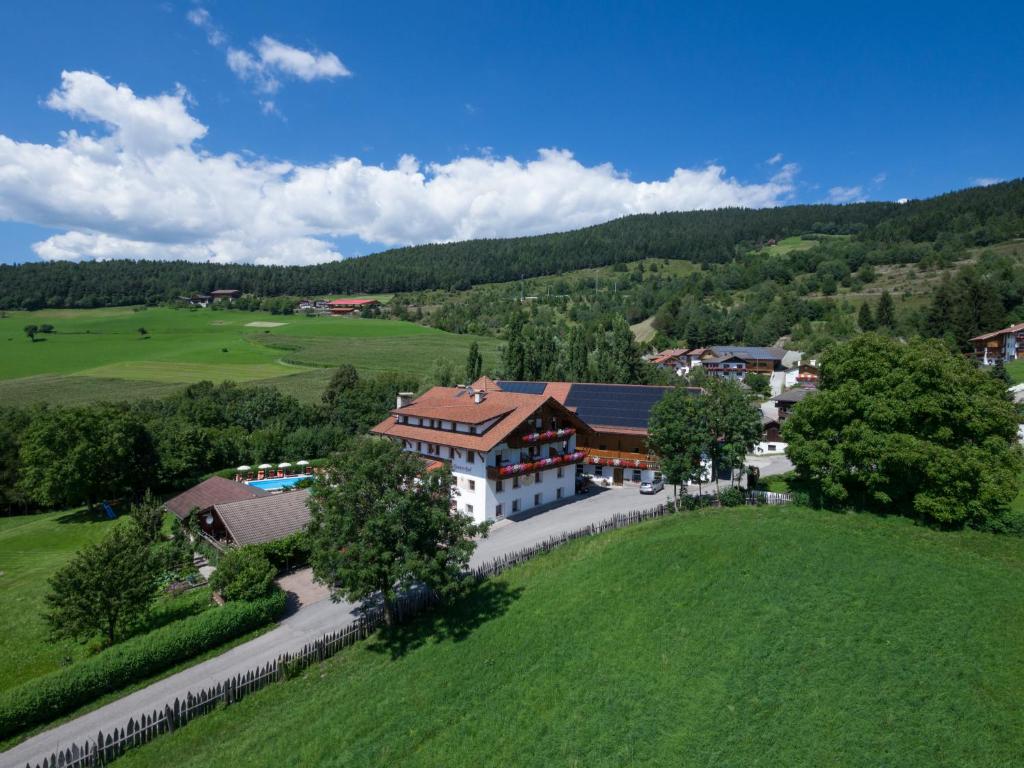 une vue aérienne sur une maison dans un champ verdoyant dans l'établissement Residence Hauserhof, à Rodengo