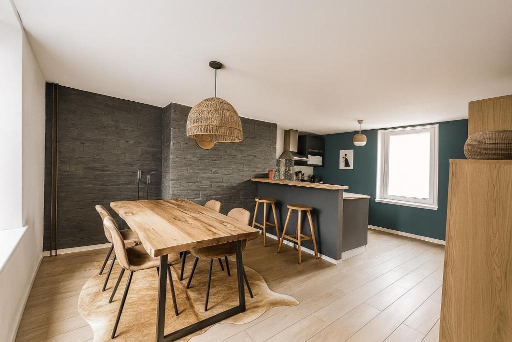 une cuisine et une salle à manger avec une table et des chaises en bois dans l'établissement Superbe Duplex de 2 Chambres au cœur de Gouvieux, à Gouvieux