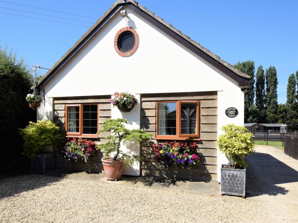 a white house with flowers in front of it at 1 bed in Bradford-on-Avon 58771 in Erlestoke
