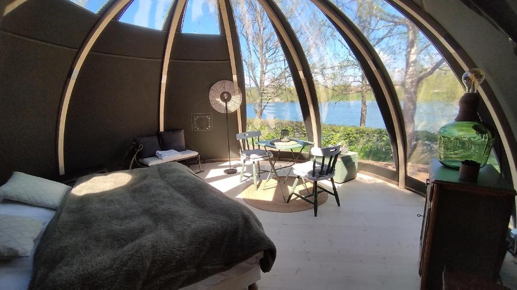a bedroom with a bed and a large window at Bulle de l'étang - Etat Nature in Magnières
