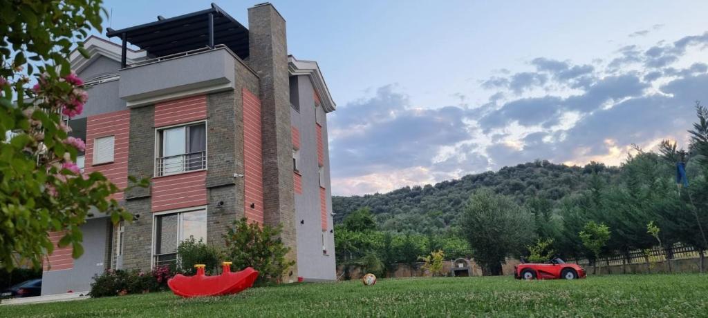 una casa con un coche rojo estacionado frente a ella en Syzes, en Polisi i Vogël
