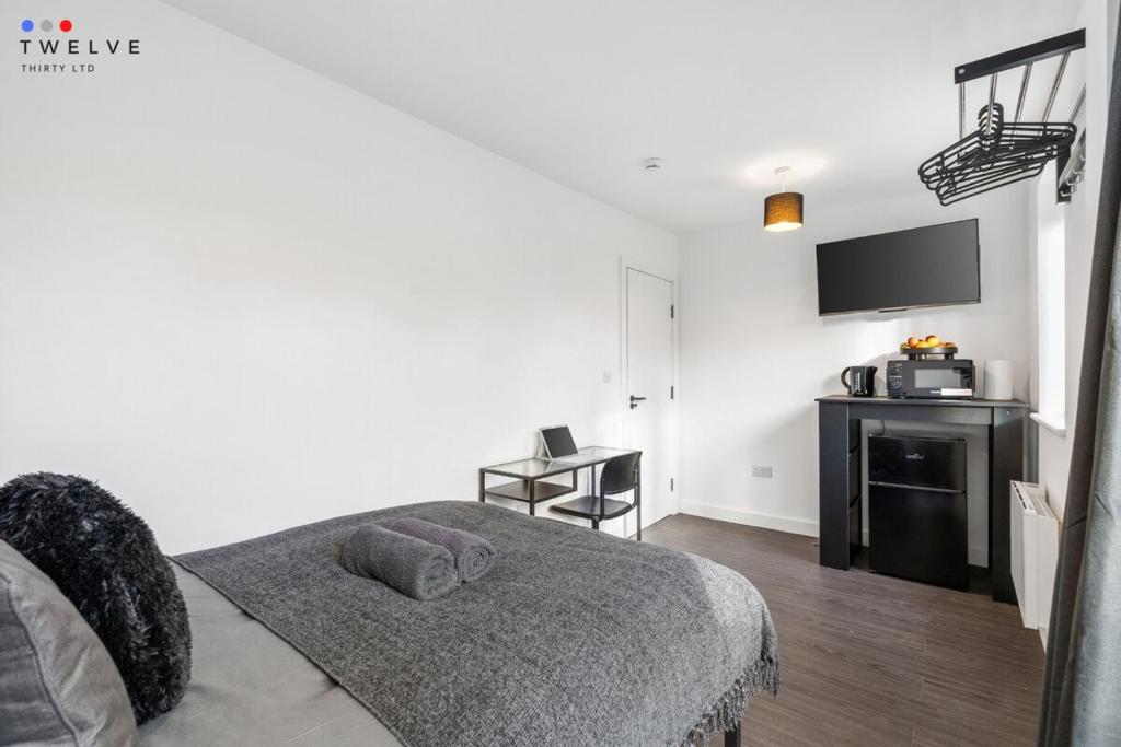 a bedroom with a bed and a tv on the wall at Bright & Modern Room in Brixton - Shared Bathroom in London