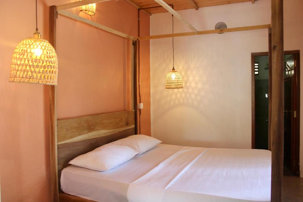 a bed in a room with two pendant lights at Solmate Collective Guesthouse - Madiha in Matara
