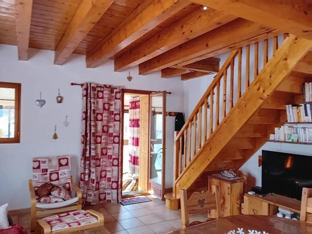 ein Wohnzimmer mit einer Holztreppe und einem TV in der Unterkunft Chalet moderne à Formiguères de 80 m² avec terrasse in Formiguères