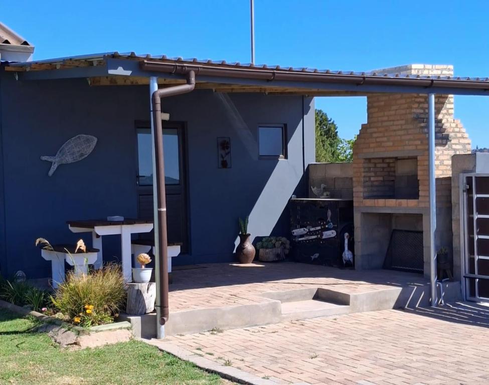 a patio with awning and a table and a grill at Korhaansnest in Vredenburg
