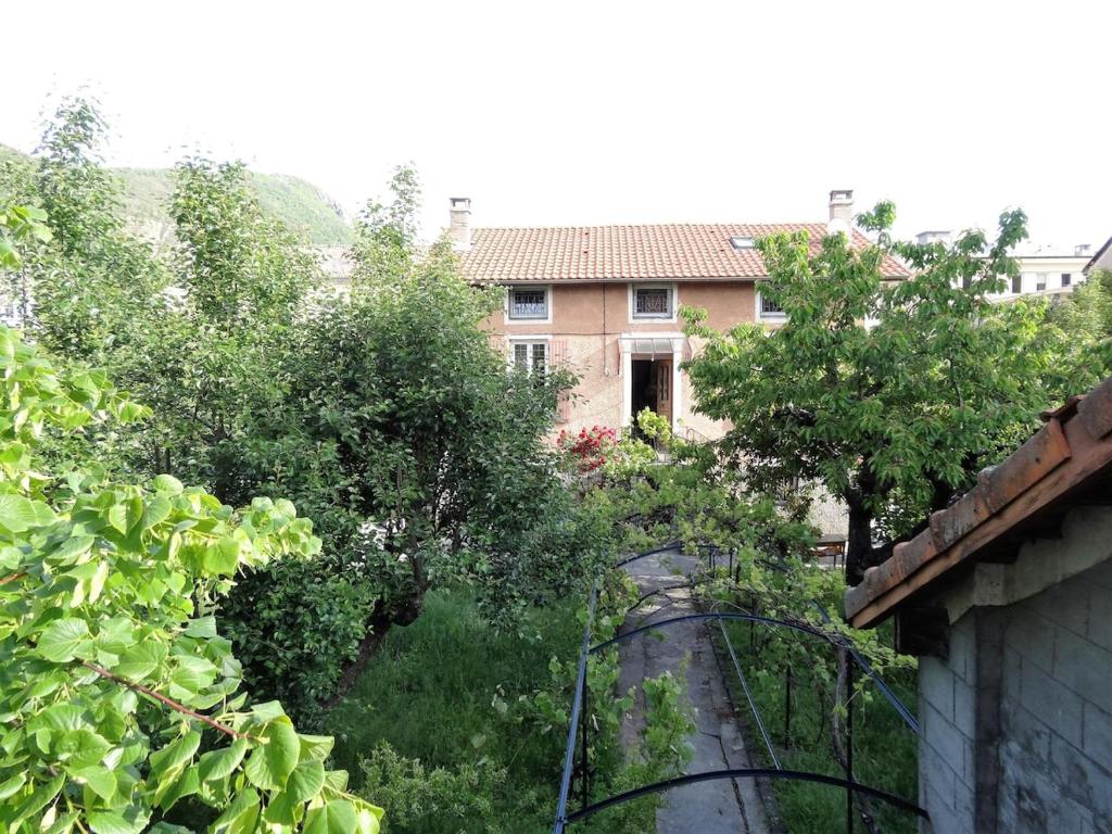 a view of a house from a yard with trees at Beautiful apartment in Provençal residence with garden and WiFi in Digne-les-Bains