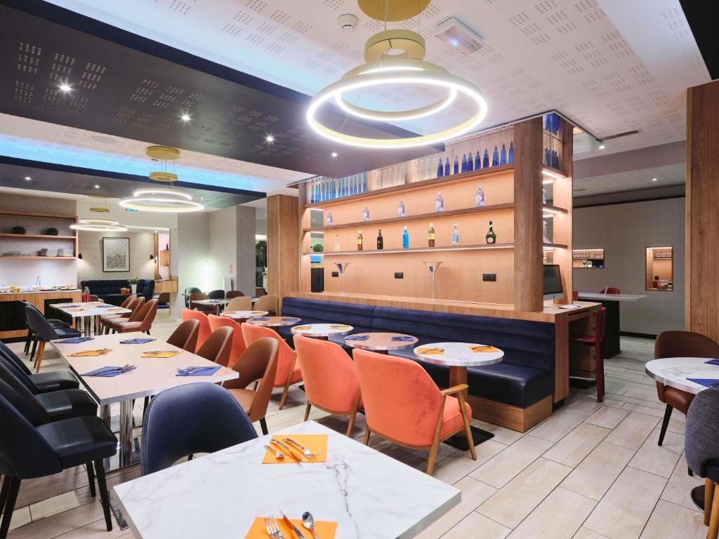 シャルトルにあるMercure Chartres Centre Cathedraleのレストラン内のテーブルと椅子のあるダイニングルーム