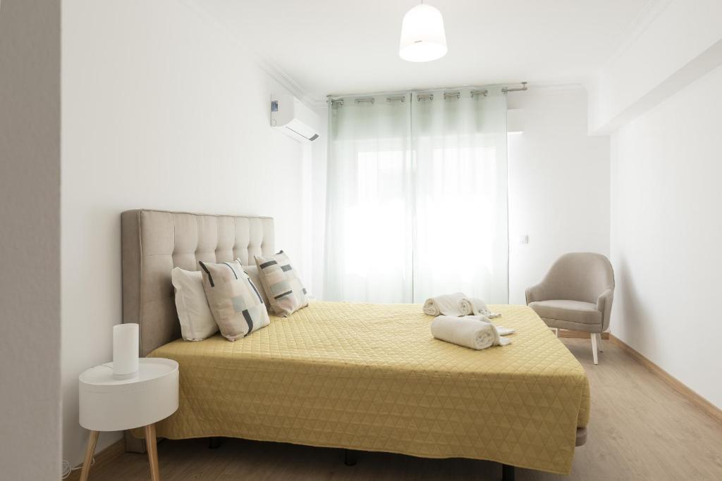 ein Schlafzimmer mit einem Bett mit gelber Tagesdecke in der Unterkunft Miral Beachside 3 - by HD Properties in Caliços