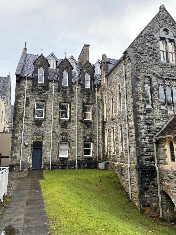 an old castle with a grass yard in front of it at Moat House 1 in Fort Augustus