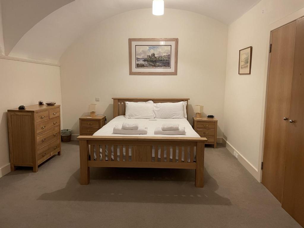een slaapkamer met een bed met 2 nachtkastjes bij Moat House 1 in Fort Augustus