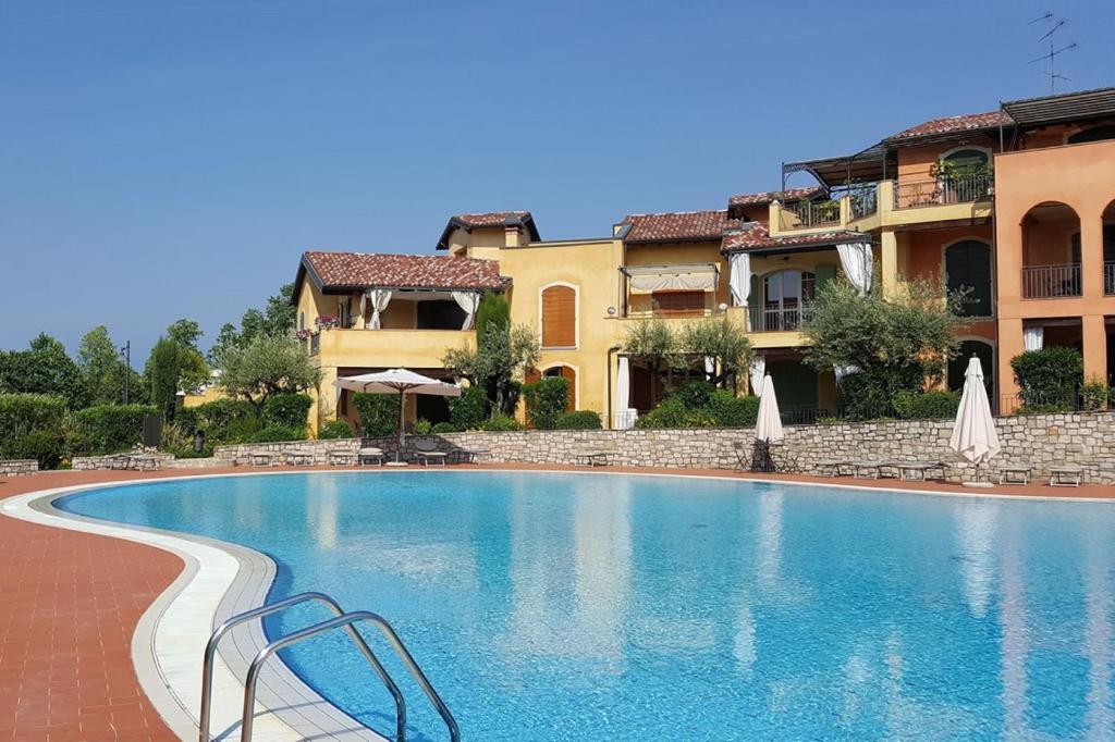 a large swimming pool in front of a building at Borgo del Torchio C8 ByBookinggardalake in Manerba del Garda