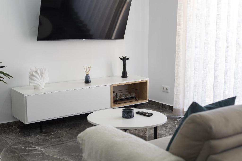 a living room with a white couch and a table at Espadarte - Sea view by HD in Quarteira