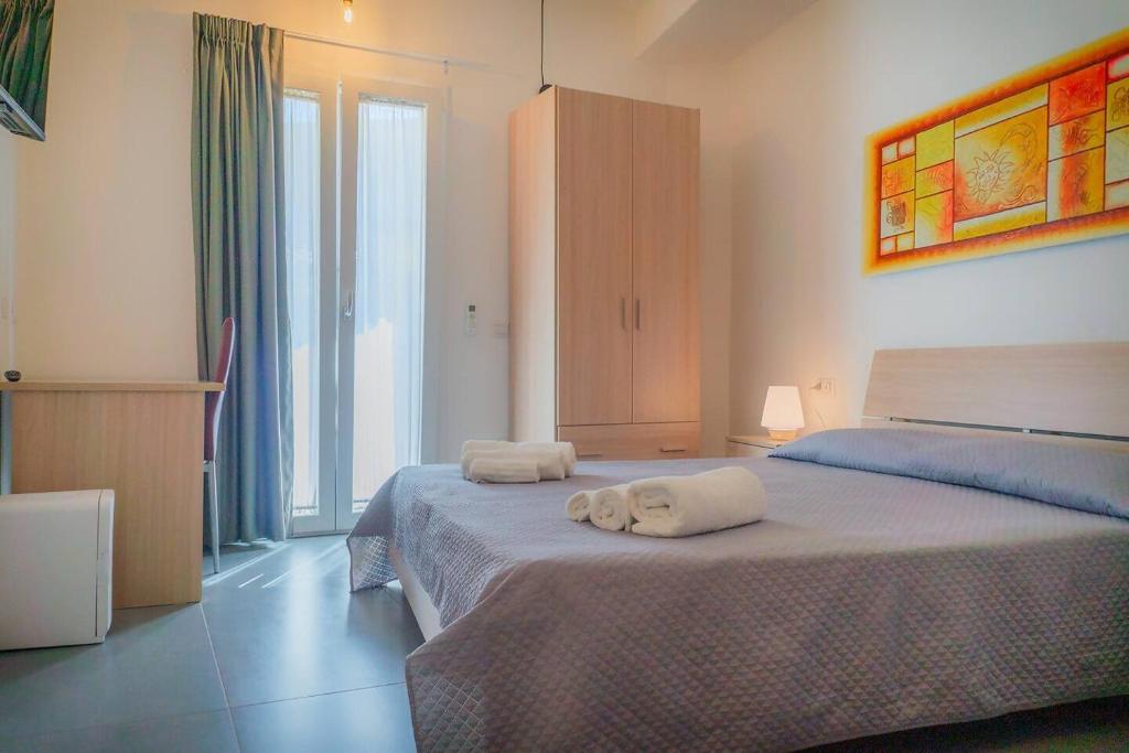 Un dormitorio con dos camas con toallas encima. en Tortolì Old Town, en Tortolì