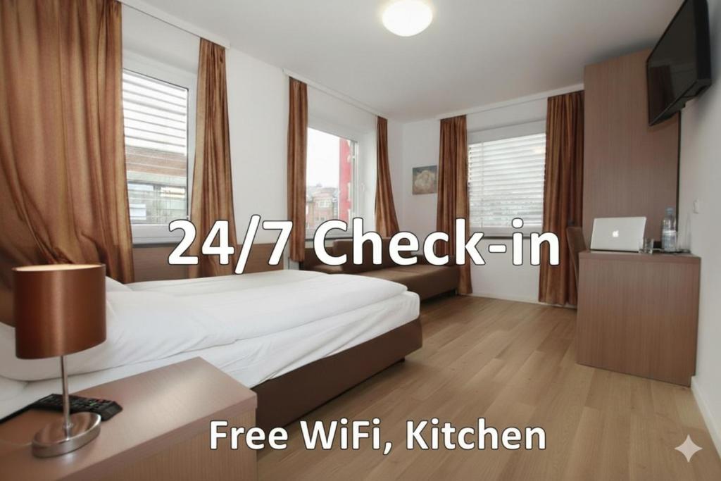 a bedroom with a bed and a desk with a television at Apartment Hotel am Sand in Hamburg