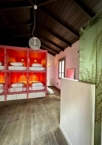 a room with red and green walls and a room with beds at Pink Mango Hostel in Athens