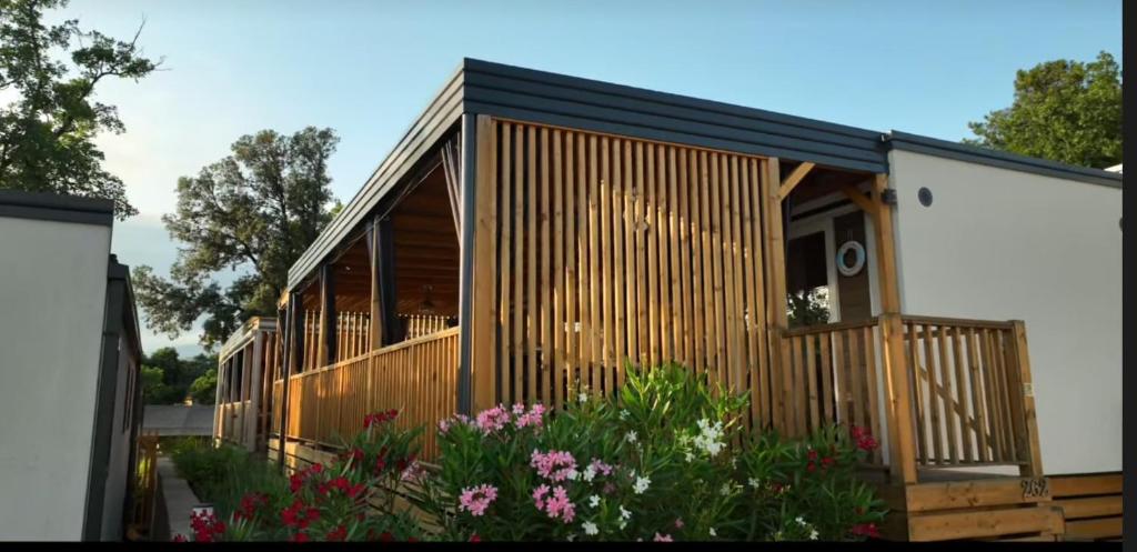a tiny house with a deck and flowers at 262 mobile home Selce in Selce