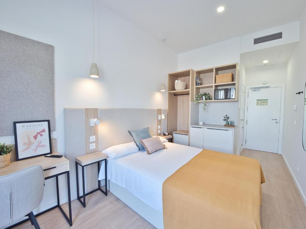 um quarto com uma grande cama branca e uma escrivaninha em Canvas Sevilla Lago em Sevilha