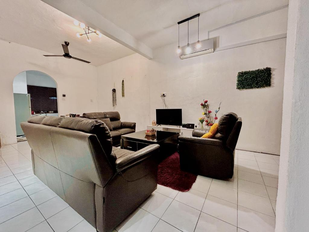 un salon avec deux canapés et une télévision dans l'établissement Cozy 10 Entire House 4 Bedroom At Alma Bukit Mertajam, à Bukit Mertajam