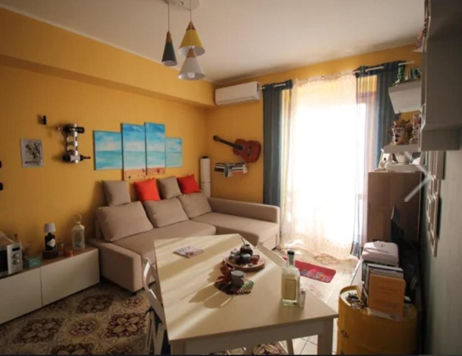 ein Wohnzimmer mit Sofa und Tisch in der Unterkunft La Casa in riva al Mare in Roccalumera