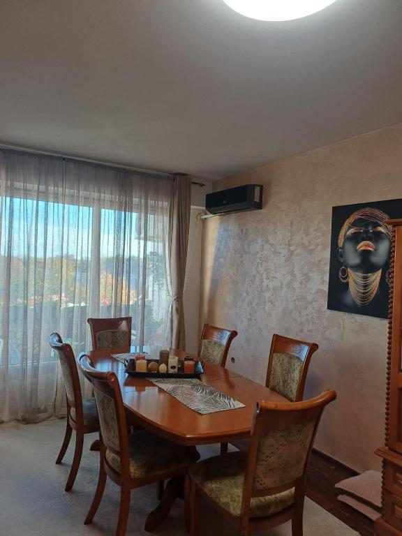 Un comedor con mesa y sillas de madera. en Apartamrnt 1, en Dobrich