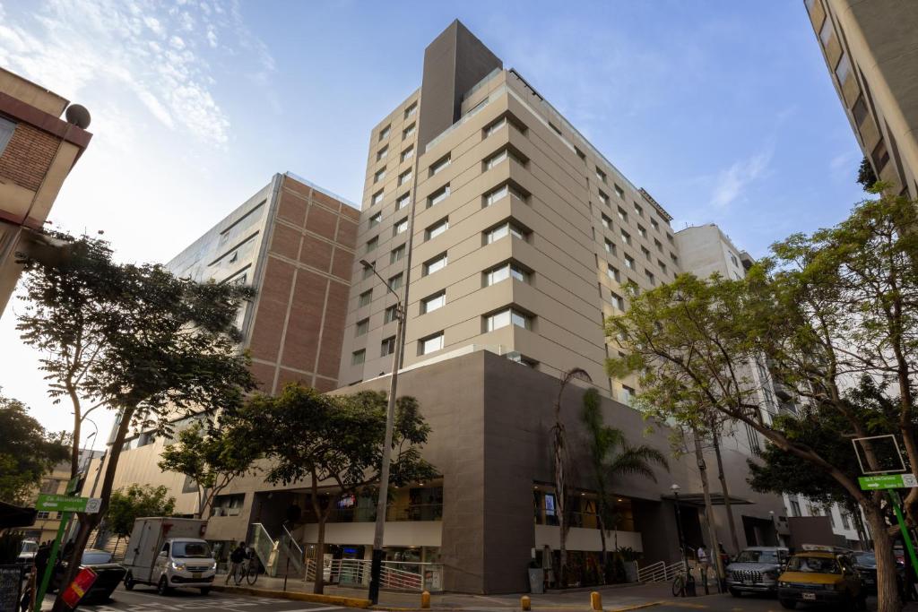 Sonesta Hotel Miraflores في ليما: مبنى أبيض طويل في أحد شوارع المدينة