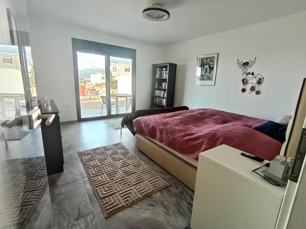 1 dormitorio con 1 cama y puerta a un balcón en Apartmani Kasa, en Rap