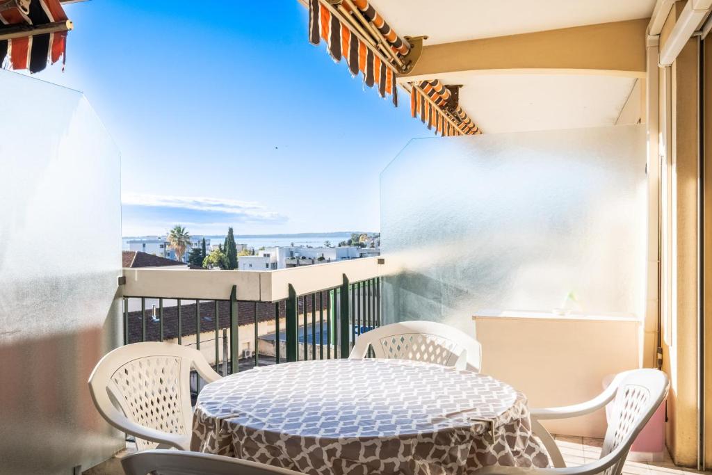 a patio with a table and chairs on a balcony at meublé tourisme 3 étoiles vue mer in Golfe-Juan