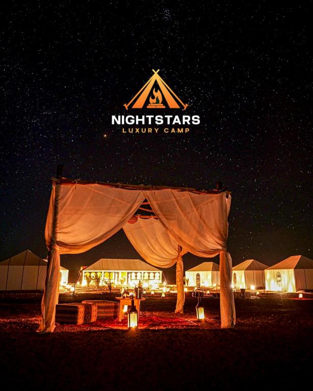 a tent with a sign that reads night stars luxury camp at NightStars Luxury Camp in Merzouga