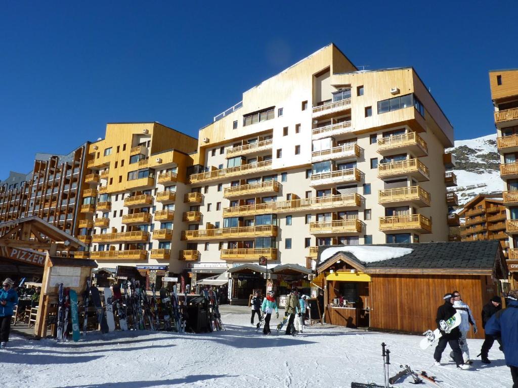 a group of people standing in front of a large building at Vanoise Appartements VTI in Val Thorens