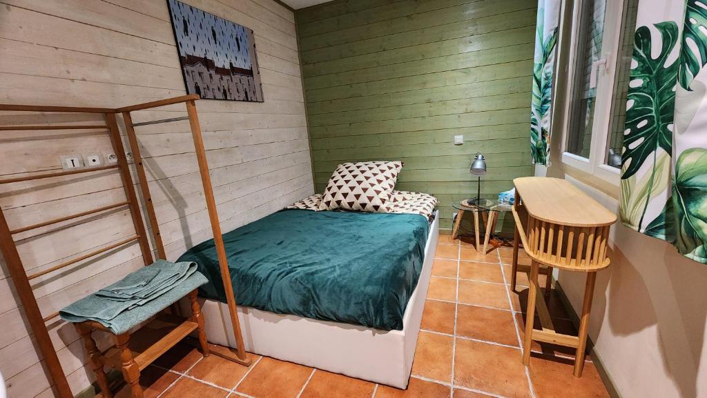 a small room with a bed and a table at L'Escale - private bed, shower room & kitchen in Blagnac