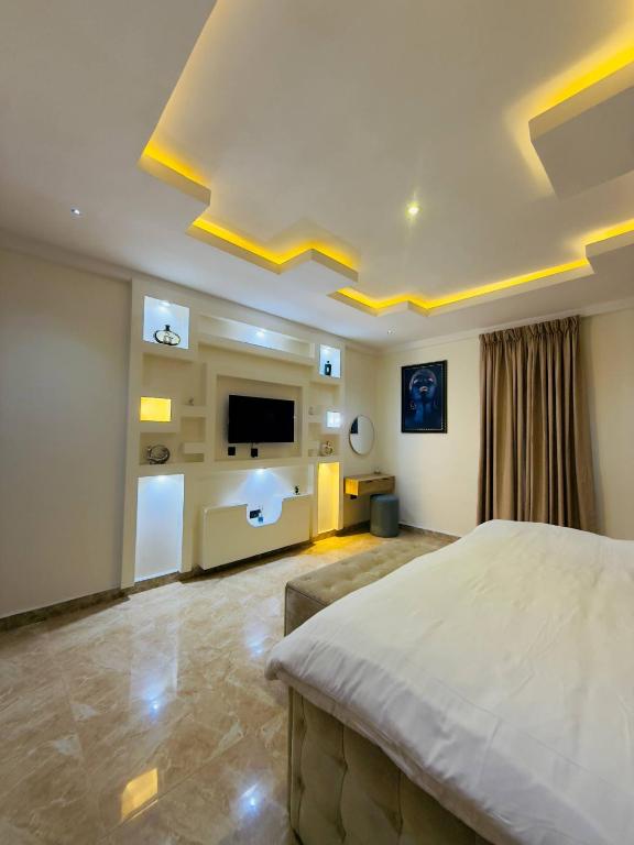 1 dormitorio grande con 1 cama grande y TV de pantalla plana en The bloom apartment, en Mama