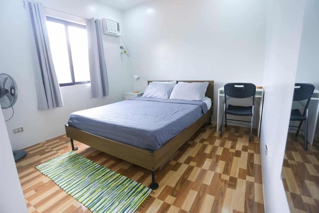 ein Schlafzimmer mit einem Bett und einem Stuhl darin in der Unterkunft Mommy Irenes Place in Antipolo