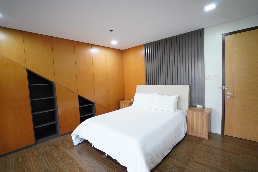 a bedroom with a white bed and wooden cabinets at Vine and Canopy in Olongapo