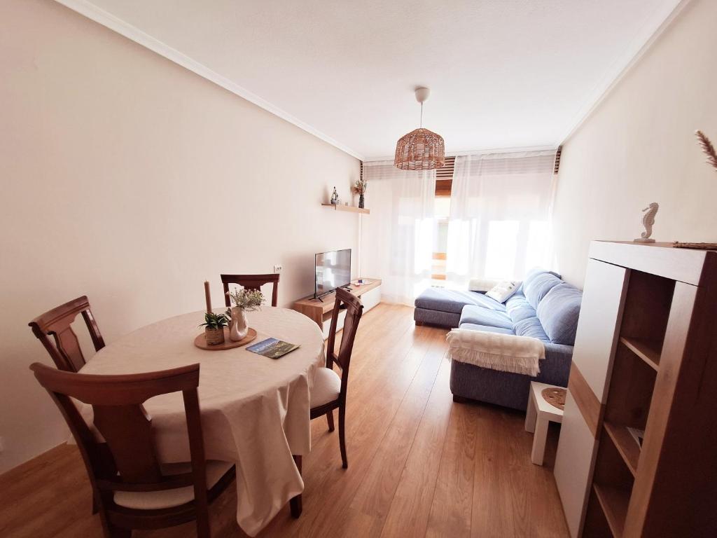 un soggiorno con un tavolo e un divano di Jona Candás Asturias a Candás