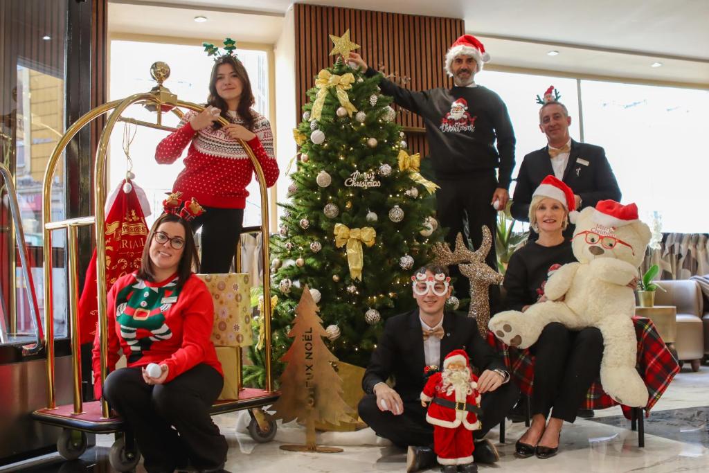a group of people in front of a christmas tree at Hotel Khla Nice in Nice