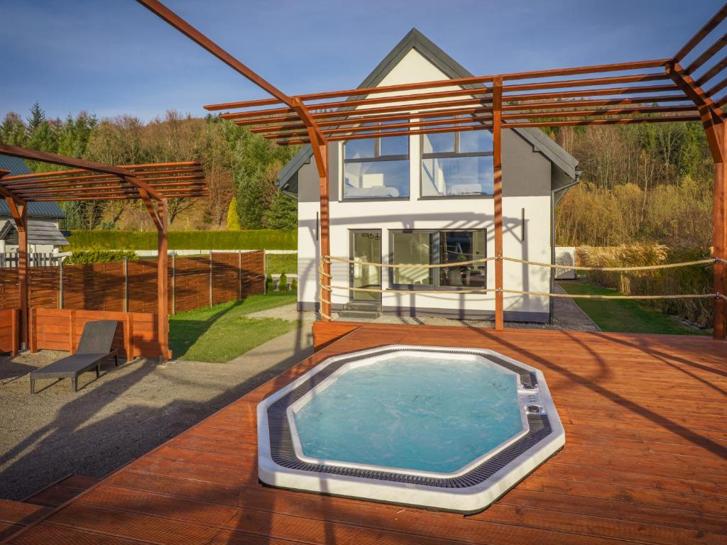 une maison avec piscine sur une terrasse en bois dans l'établissement Domki u Duszy Wielka Dusza, à Brenna