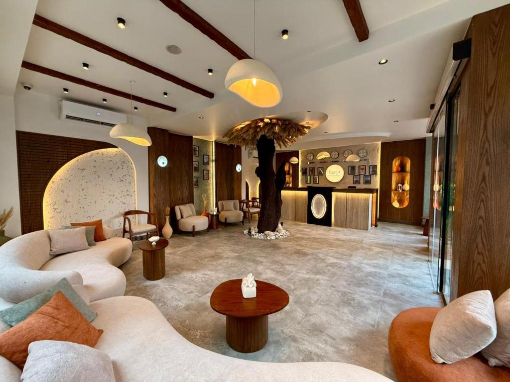 un salon avec des canapés et un arbre au milieu dans l'établissement Pyramids Spiritual Gate, au Caire