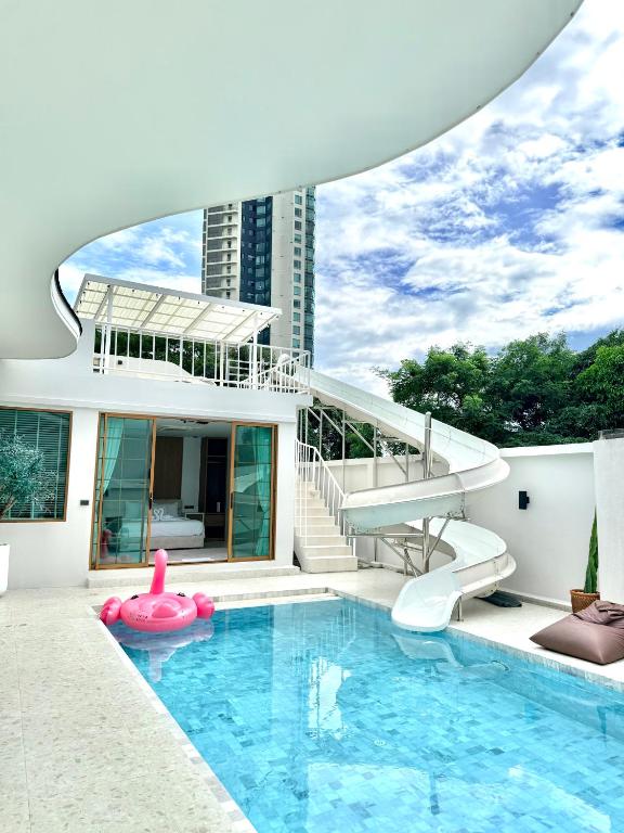 a house with a swimming pool with a slide and a swimming pool at NABI LUXURY JOMTIEn in Jomtien Beach