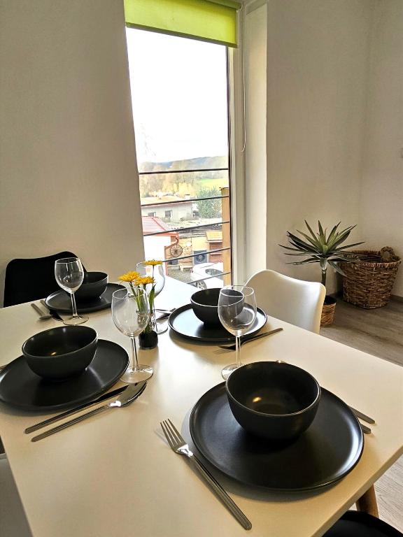 a table with black bowls and wine glasses on it at Útulný apartmán s výhledem do kraje K J Erbena in Miletín