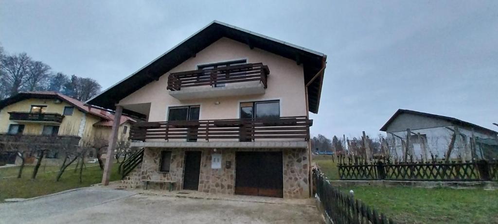 ein großes Haus mit einem Zaun davor in der Unterkunft KaTi Hiša 