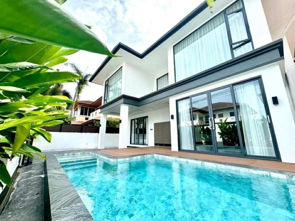 ein Swimmingpool vor einem Haus in der Unterkunft NEW Luxury 6BR Pool Villa Pattaya, 10mn Walking St in Jomtien Beach