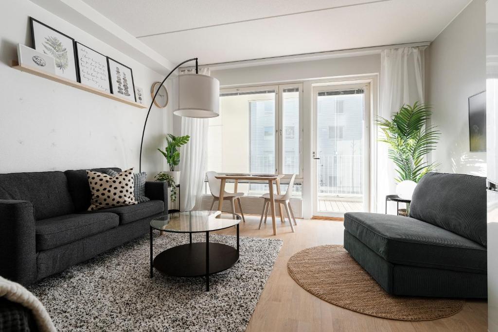a living room with a couch and a table at Stylish, 450 m walk to the Estonian ferry, Free parking and balcony in Helsinki