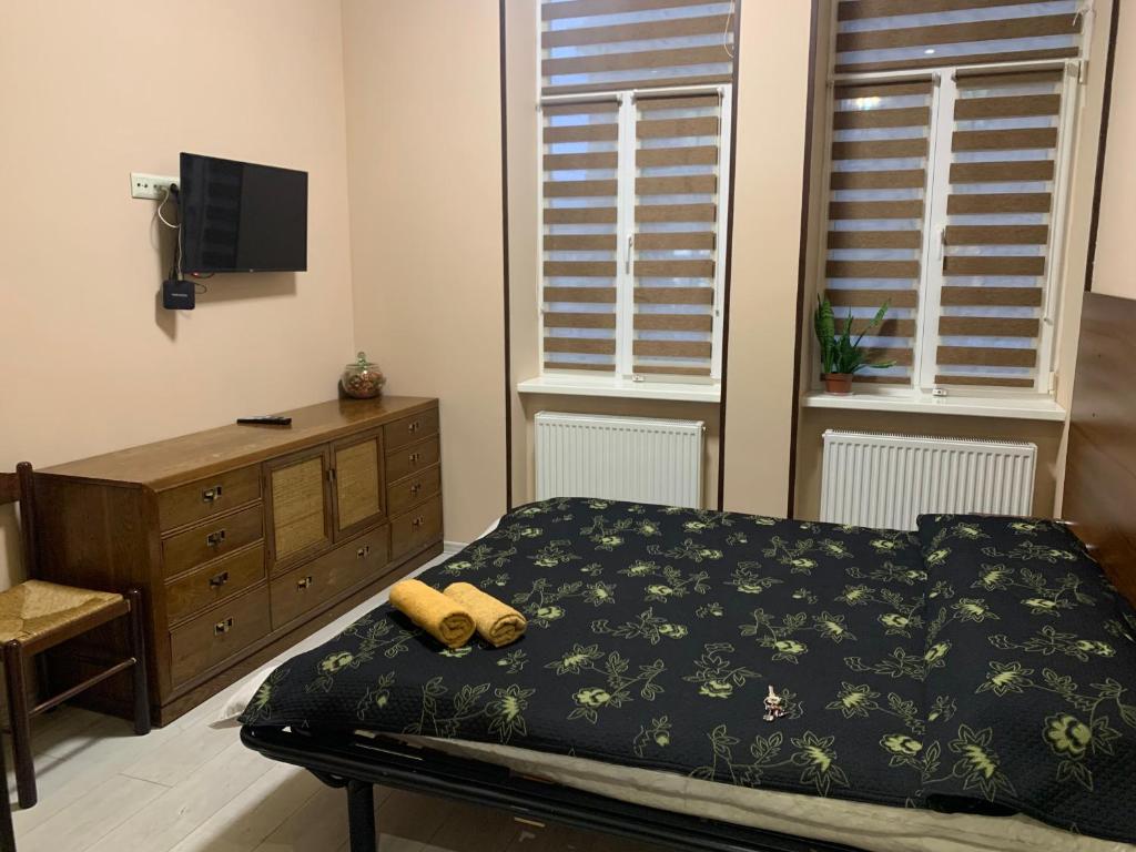 Un dormitorio con una cama y una cómoda y dos ventanas. en Apartment, en Chernivtsi