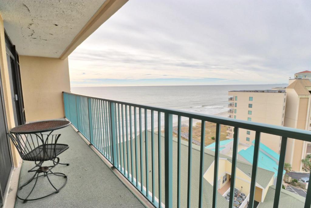 een balkon met een stoel en uitzicht op de oceaan bij Verandas 1107 in Myrtle Beach
