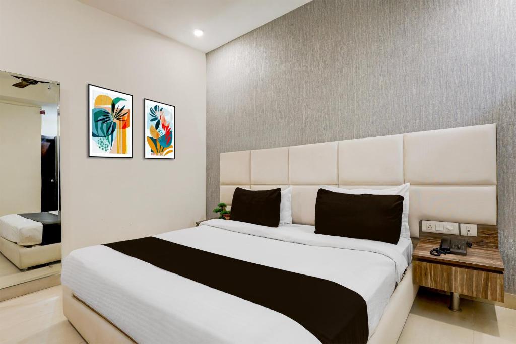 a bedroom with a large white bed with a large headboard at Super Townhouse Hotel Sec- 54 Golf Course Road in Gurgaon